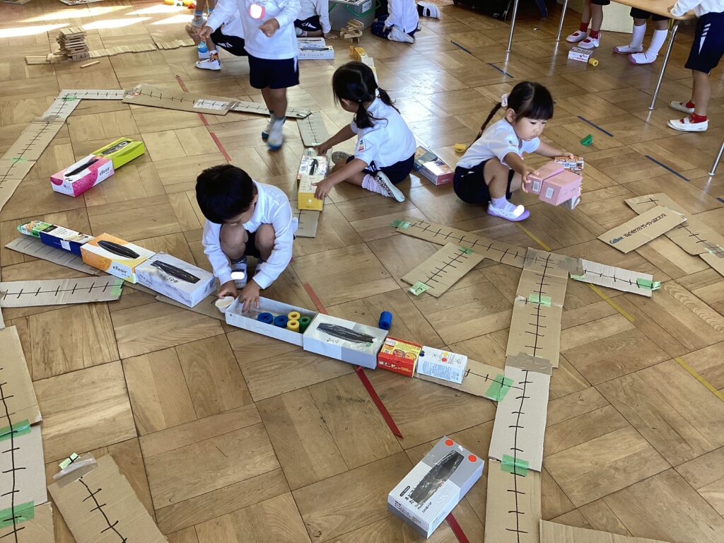 ３歳児『いっしょ』お話ページ「ともだちでんしゃ」から広げた、段ボール箱の電車を作って遊びます。 絵本を読んだ後、筒状にした段ボール箱を飾ってかっこいい電車を作り、電車ごっこをして遊びましょう。踏切の棒や線路を作って本格的にしても！☆ねらい☆ ・イメージ