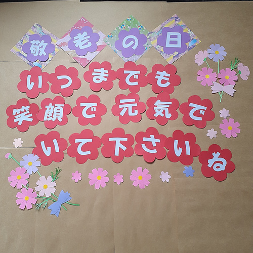 長寿を祝う敬老の日』 壁面飾り・高齢者施設向け ＊ ご老人の長寿を祈り、みんなでお祝いしましょう🦋折り紙の蝶やトンボ、沢山の秋の花が囲み、優しい雰囲気を演出します。 綺麗な色の組み合わせが品の良い壁面飾りです。 ＊伝承折り紙のトンボはちょっと時間がかかる