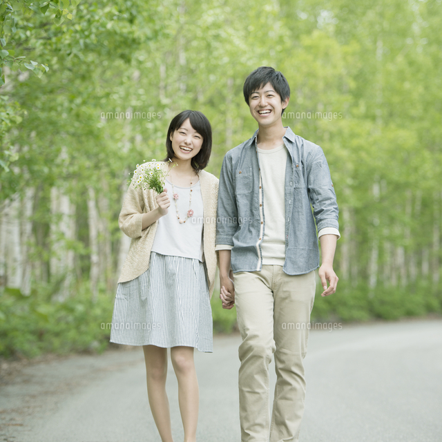 手をつなぎジャンプするカップル 10250004478 の写真・イラスト素材アマナイメージズ