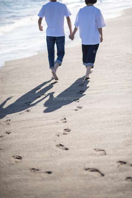 夕暮れに手を繋ぐカップルのシルエット 11031049026 の写真・イラスト素材アマナイメージズ